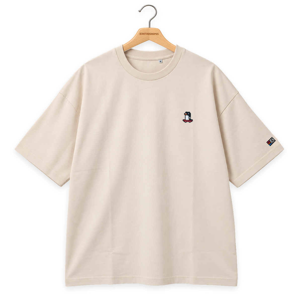 Pixel Pinguin Mit Skateboard – Besticktes Bio Oversized T-Shirt · Beige · Bügel A · Bügel V5