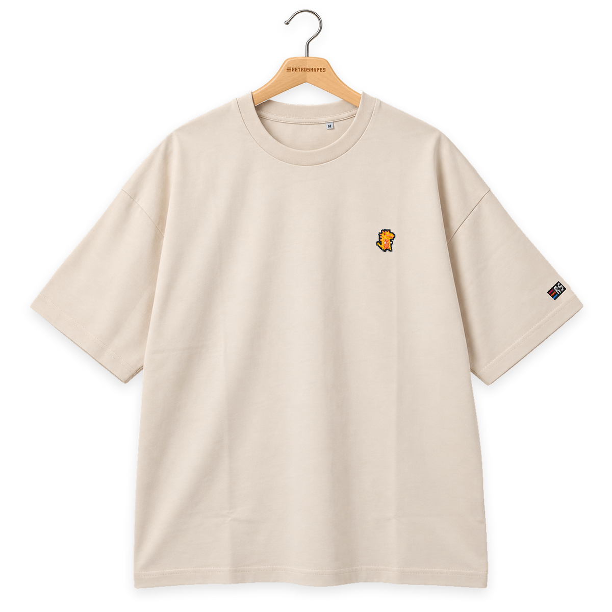 Pixel Dino Orange – Besticktes Bio Oversized T-Shirt · Beige · Bügel A · Bügel V5